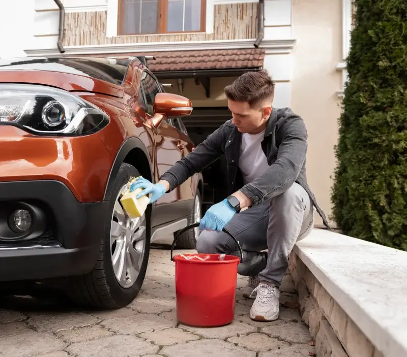 Lavage auto à domicile Saint-Loup-de-Naud : professionnel intervenant sur un véhicule